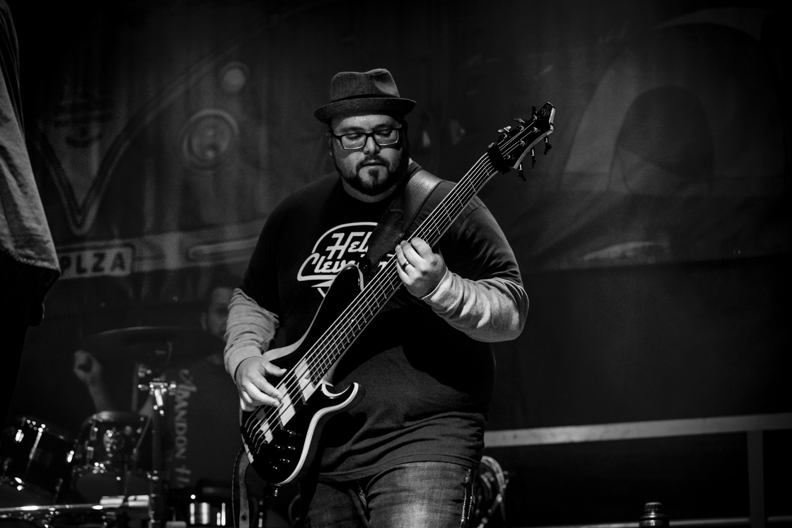 Bassist lit from the side against a painted backdrop