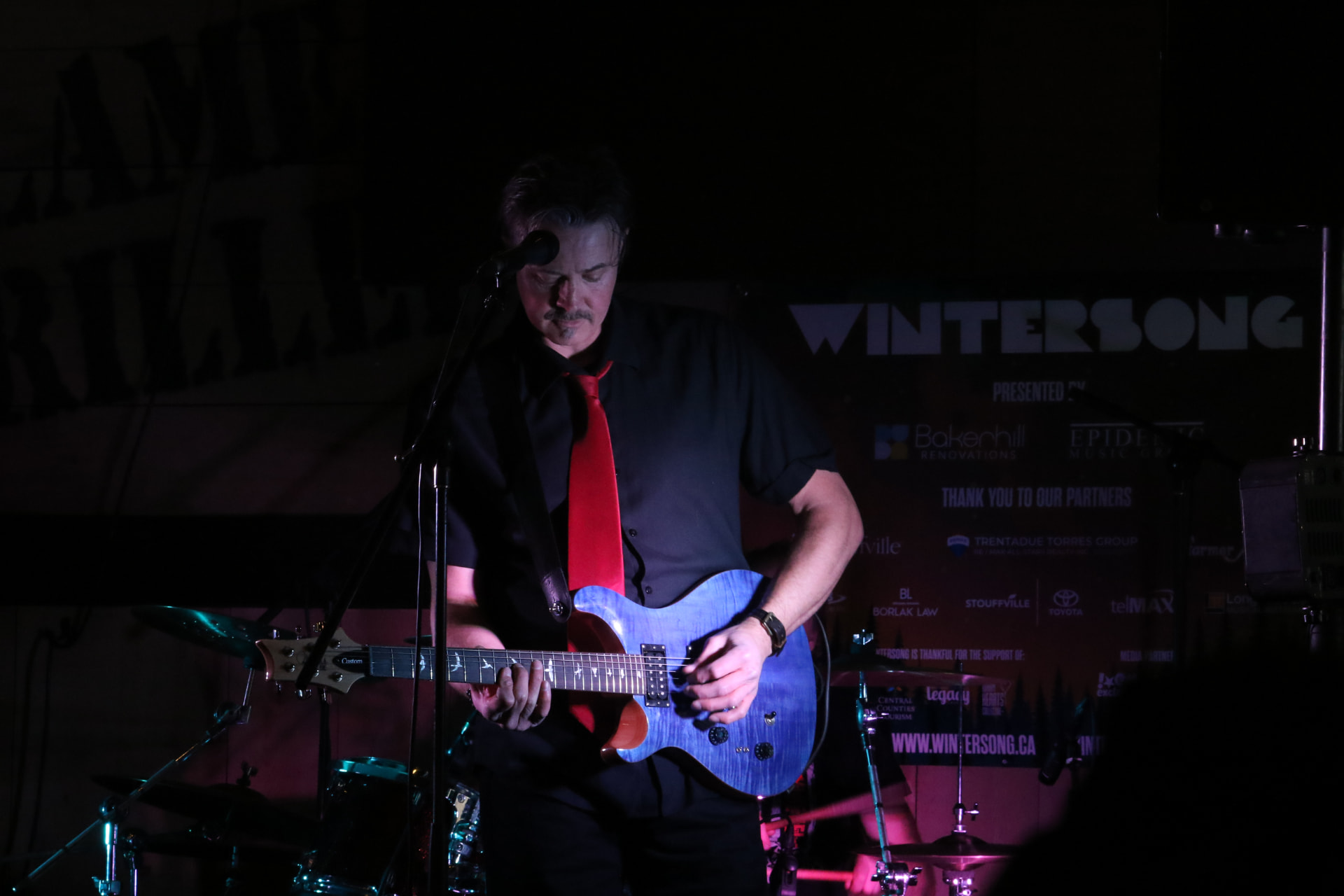 Dave playing a blue PRS guitar at Wintersong