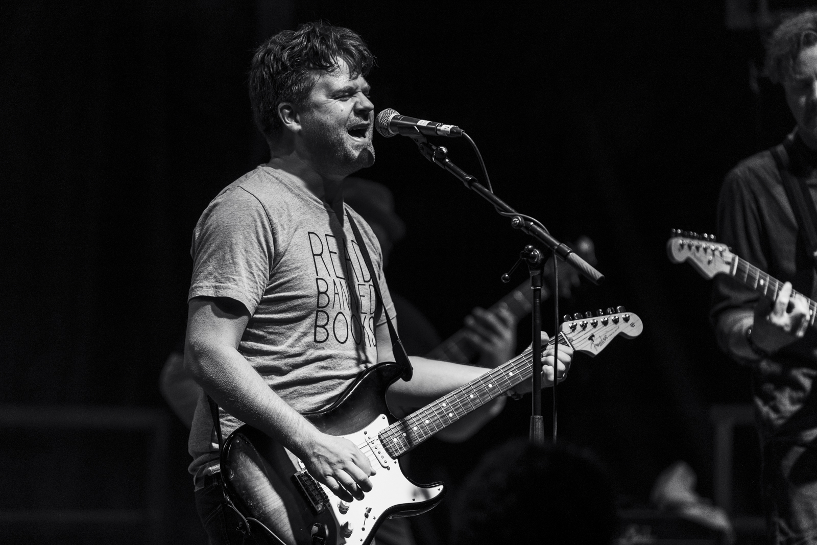 Singer leaning into the microphone mid-chorus