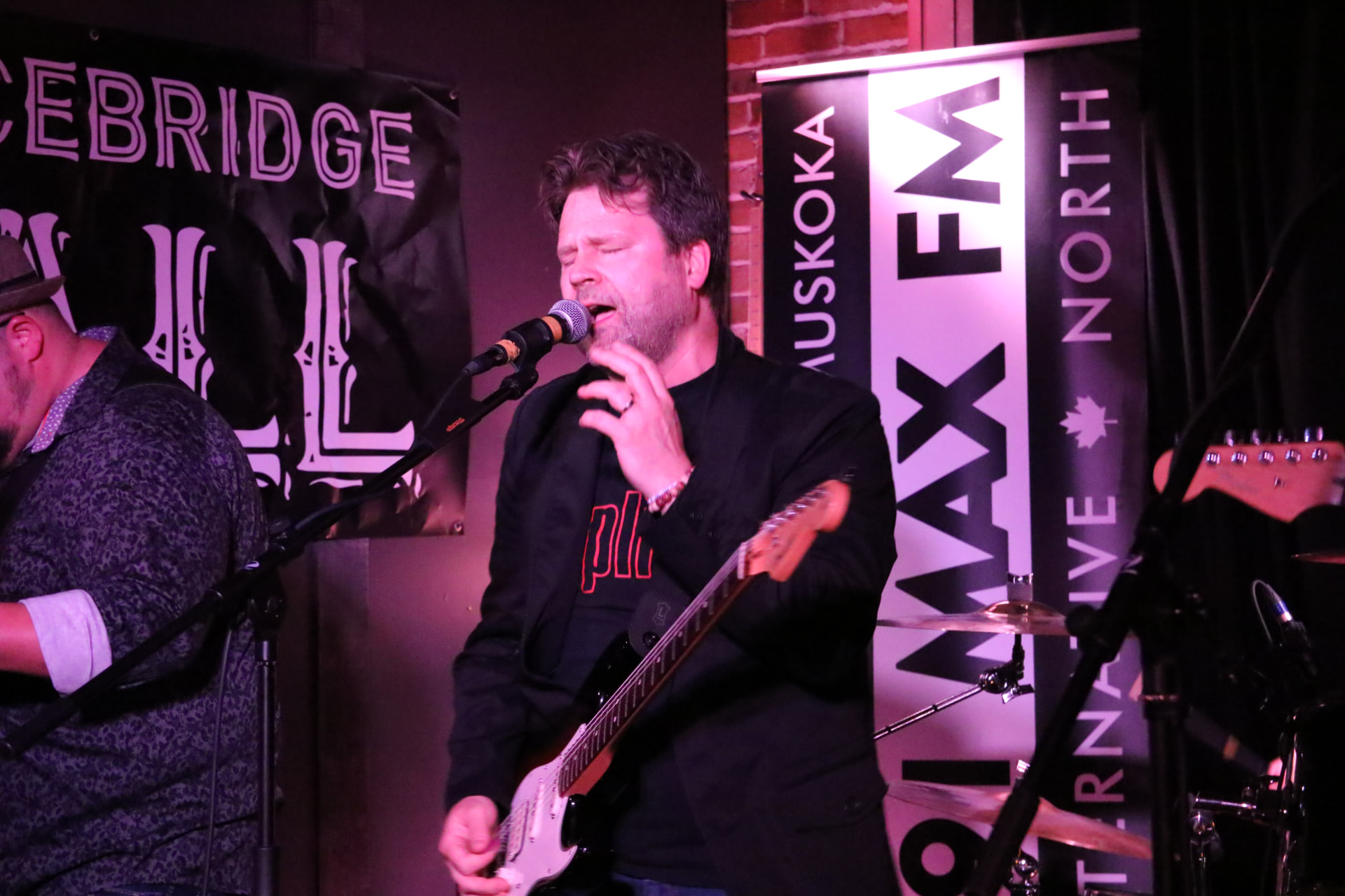 Kevin singing into the mic while playing a Strat at Bracebridge Hall